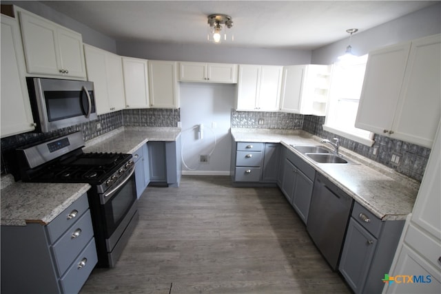 kitchen with dark wood-type flooring, appliances with stainless steel finishes, sink, and white cabinets