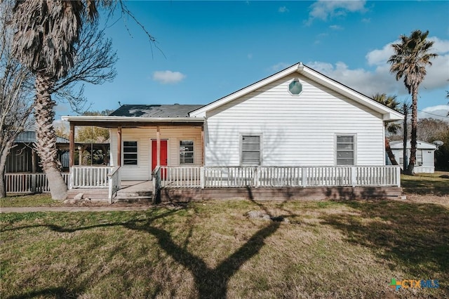 rear view of property with a lawn and a porch