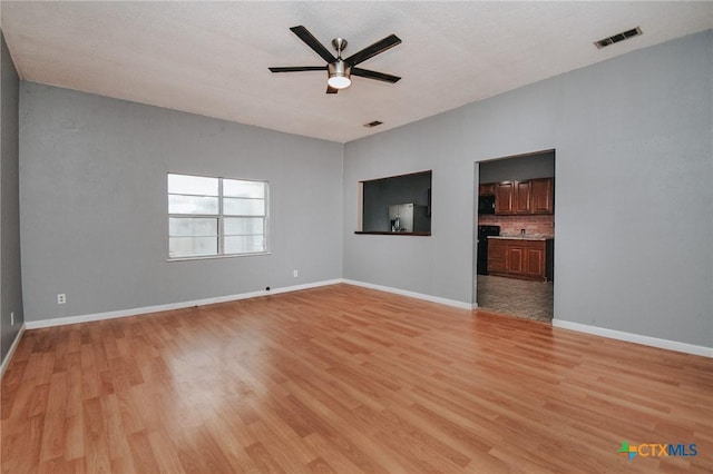 unfurnished living room featuring ceiling fan and light wood-type flooring