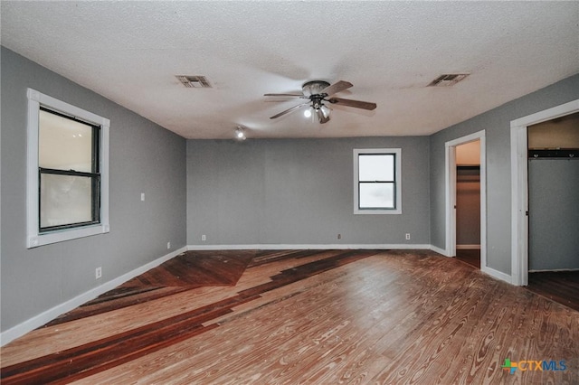 unfurnished bedroom featuring ceiling fan, hardwood / wood-style floors, and a textured ceiling