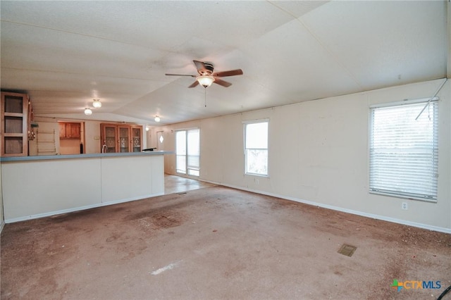 unfurnished living room with vaulted ceiling, concrete floors, and ceiling fan