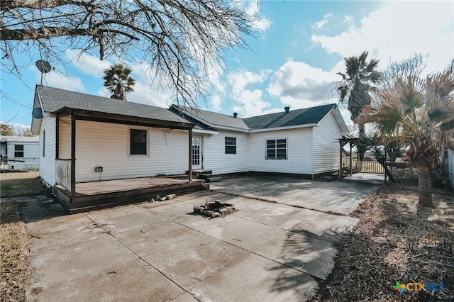 rear view of property with a fire pit and a patio area