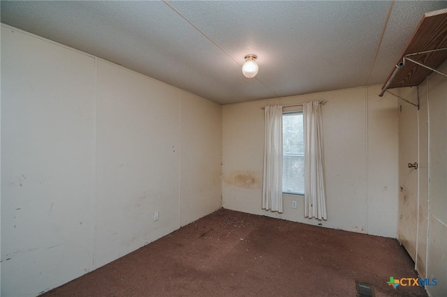 unfurnished room featuring a textured ceiling