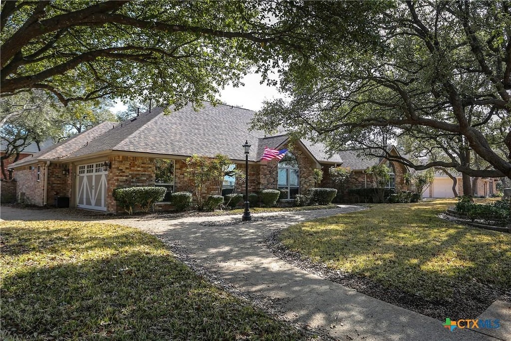 view of front of house featuring a garage and a front lawn