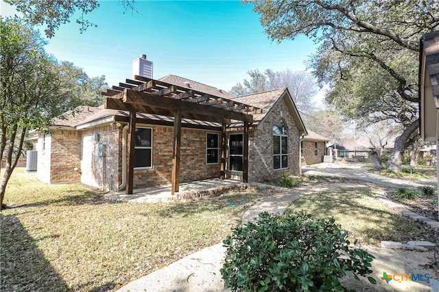 rear view of property with a pergola, a lawn, and a patio area