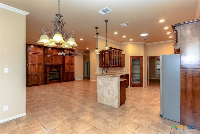 kitchen with hanging light fixtures, ornamental molding, stainless steel fridge, and kitchen peninsula