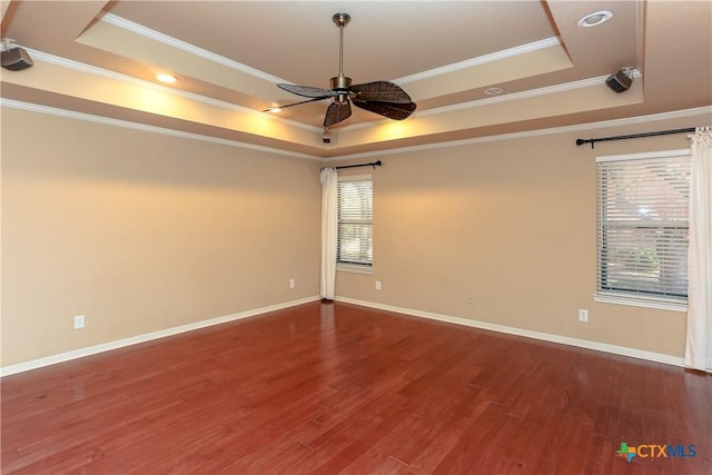 spare room featuring hardwood / wood-style flooring, ceiling fan, and a tray ceiling