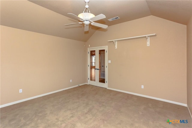 carpeted empty room with french doors, ceiling fan, and vaulted ceiling