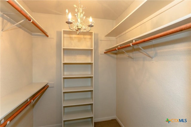 walk in closet with a notable chandelier