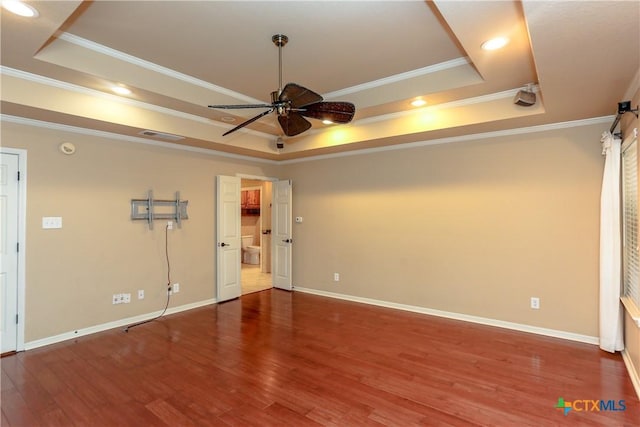 interior space featuring a raised ceiling, wood-type flooring, crown molding, and ceiling fan