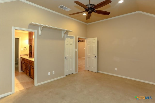 unfurnished bedroom featuring lofted ceiling, connected bathroom, light carpet, ornamental molding, and ceiling fan