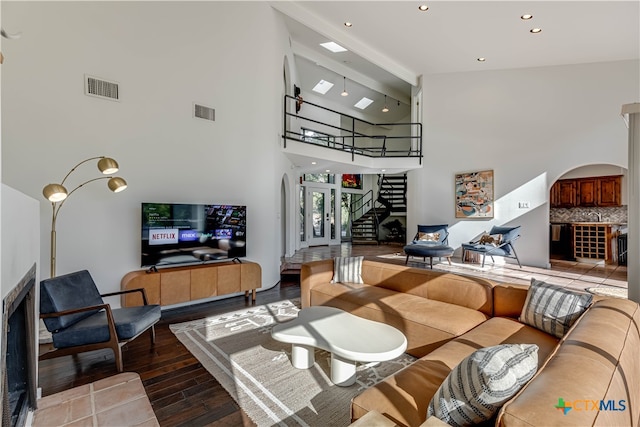 living room featuring hardwood / wood-style flooring, beam ceiling, and high vaulted ceiling