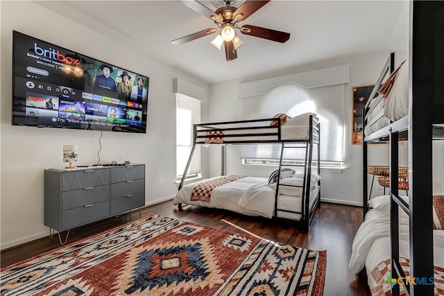 bedroom with dark hardwood / wood-style flooring and ceiling fan