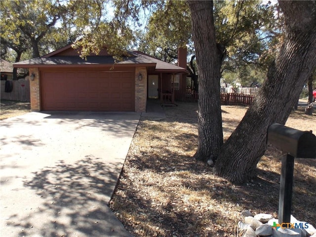 2 Rawhide Cir, Belton, TX 76513 - view of front of property featuring driveway, brick siding, an attached garage, and a chimney