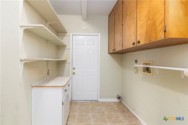 clothes washing area with hookup for an electric dryer, washer hookup, cabinets, and light tile patterned flooring