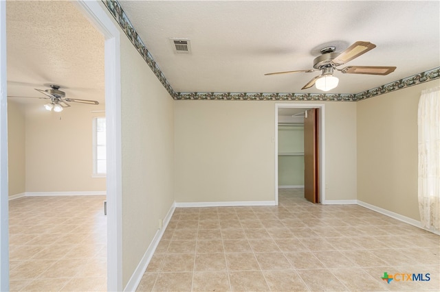 empty room featuring ceiling fan and a textured ceiling