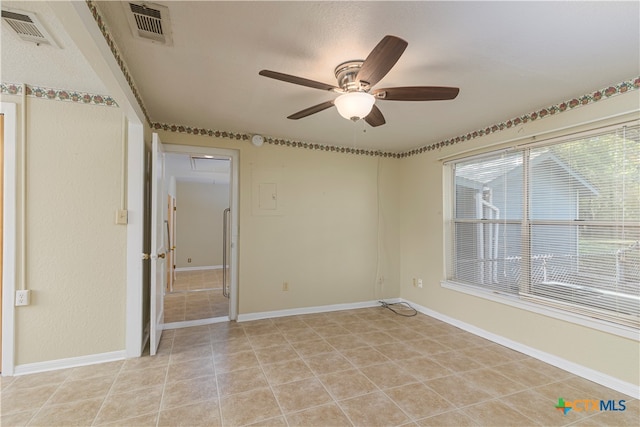 unfurnished room with ceiling fan and light tile patterned floors