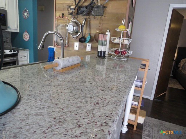 310 Rattan Dr, Victoria, TX 77901 - kitchen featuring wood finished floors, white cabinetry, and stainless steel microwave