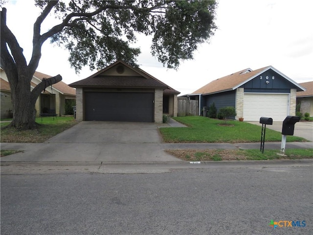 310 Rattan Dr, Victoria, TX 77901 - ranch-style house with a front lawn, a garage, brick siding, and board and batten siding