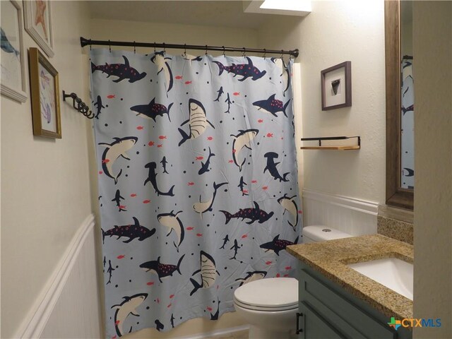 310 Rattan Dr, Victoria, TX 77901 - bathroom with vanity, a shower with shower curtain, and wainscoting