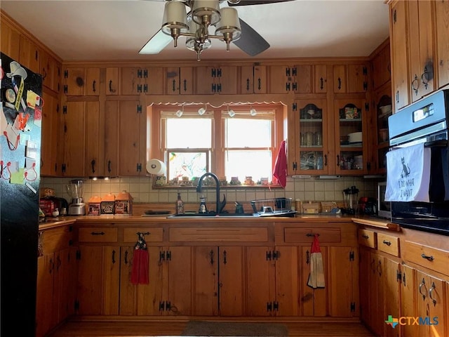 1101 S 17th St, Copperas Cove, TX 76522 - kitchen featuring ceiling fan, black appliances, tasteful backsplash, brown cabinetry, and a sink