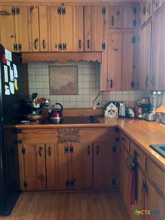 1101 S 17th St, Copperas Cove, TX 76522 - kitchen with black appliances, decorative backsplash, light wood-style flooring, light countertops, and brown cabinets