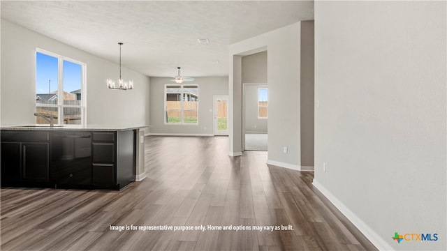 interior space with dark wood-type flooring, a chandelier, decorative light fixtures, and a healthy amount of sunlight