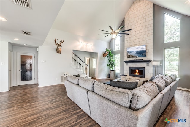 living room featuring high vaulted ceiling, ceiling fan, dark hardwood / wood-style floors, and a fireplace