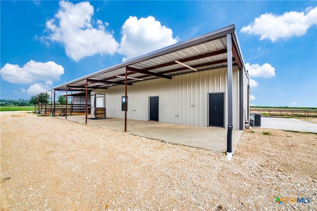 view of outbuilding with central air condition unit and a rural view