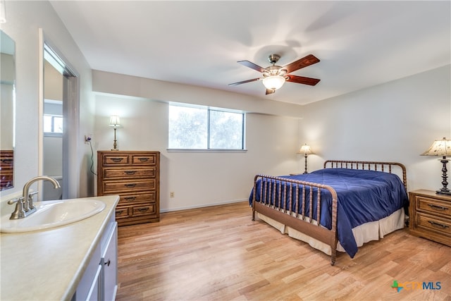 bedroom featuring sink, ceiling fan, and light hardwood / wood-style flooring