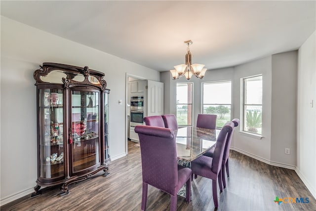 dining area with dark hardwood / wood-style floors and an inviting chandelier