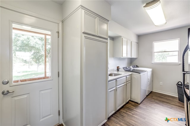 washroom featuring dark hardwood / wood-style flooring, cabinets, and independent washer and dryer