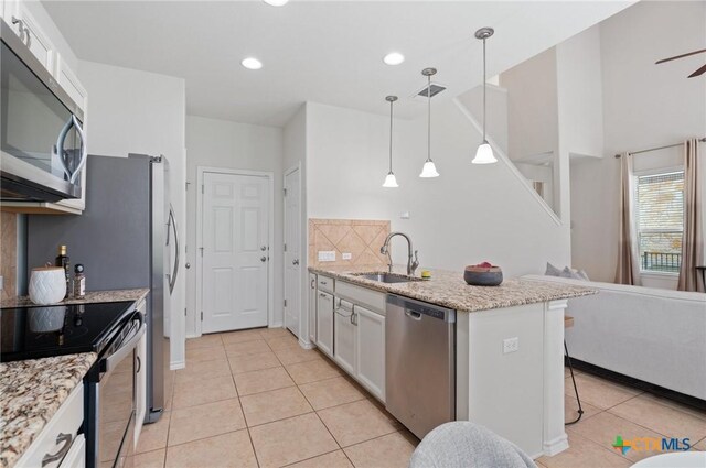 2105 Town Centre Dr Unit 42, Round Rock, TX 78664 - kitchen with stainless steel appliances, light tile patterned floors, a breakfast bar, hanging light fixtures, and recessed lighting
