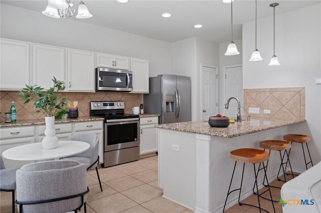 2105 Town Centre Dr Unit 42, Round Rock, TX 78664 - kitchen with appliances with stainless steel finishes, tasteful backsplash, white cabinetry, a peninsula, and recessed lighting