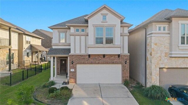 2105 Town Centre Dr Unit 42, Round Rock, TX 78664 - view of front facade featuring stucco siding, driveway, a garage, brick siding, and roof with shingles