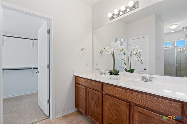 2105 Town Centre Dr Unit 42, Round Rock, TX 78664 - bathroom with double vanity, a tile shower, a spacious closet, and tile patterned floors