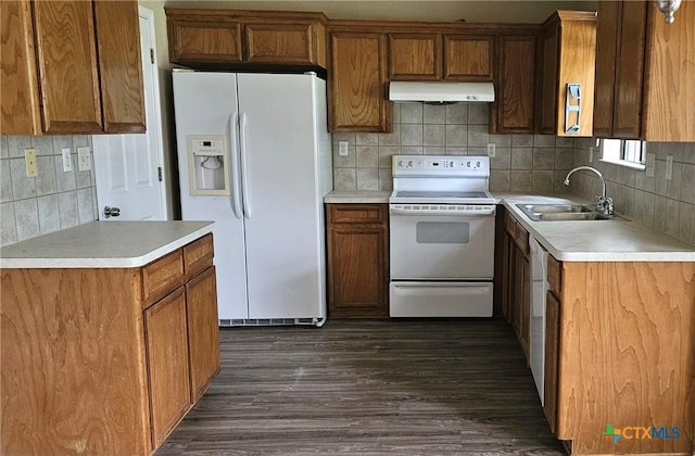 kitchen featuring white appliances, under cabinet range hood, a sink, and backsplash