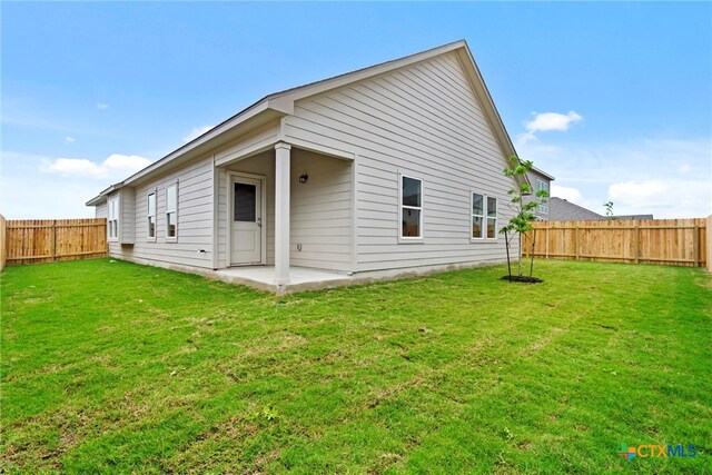 back of property featuring a lawn and a patio area