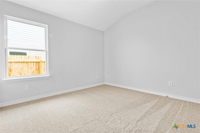 empty room with lofted ceiling and carpet