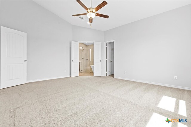 unfurnished bedroom featuring ceiling fan, connected bathroom, high vaulted ceiling, and light colored carpet