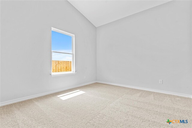 spare room featuring lofted ceiling and carpet floors