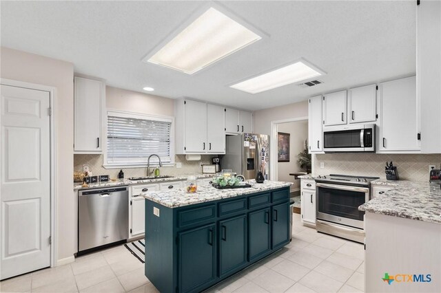 106 Westbrook Dr, Victoria, TX 77904 - kitchen featuring stainless steel appliances, white cabinets, a kitchen island, tasteful backsplash, and recessed lighting