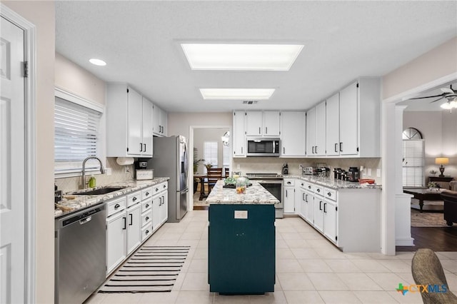 106 Westbrook Dr, Victoria, TX 77904 - kitchen featuring stainless steel appliances, a kitchen island, backsplash, white cabinetry, and recessed lighting