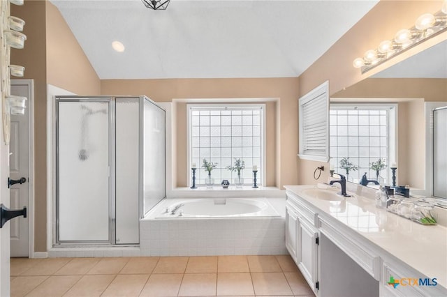 106 Westbrook Dr, Victoria, TX 77904 - full bathroom with vaulted ceiling, vanity, a shower stall, a garden tub, and tile patterned flooring