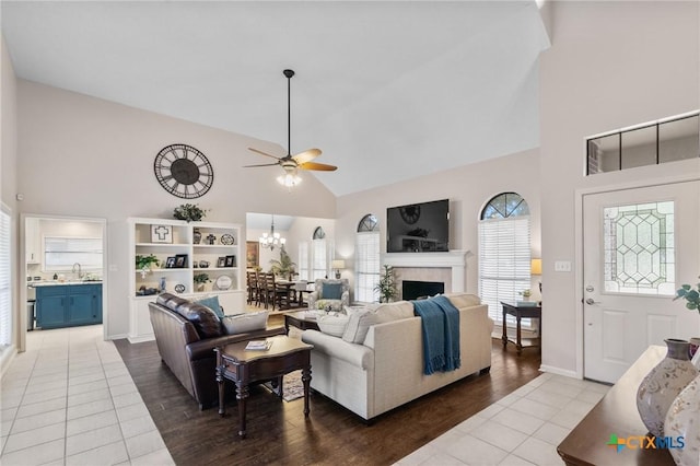 106 Westbrook Dr, Victoria, TX 77904 - living area featuring high vaulted ceiling, tile patterned flooring, ceiling fan, a fireplace, and a chandelier