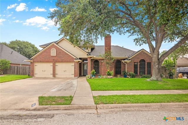 106 Westbrook Dr, Victoria, TX 77904 - traditional-style house featuring brick siding, driveway, a chimney, an attached garage, and a shingled roof