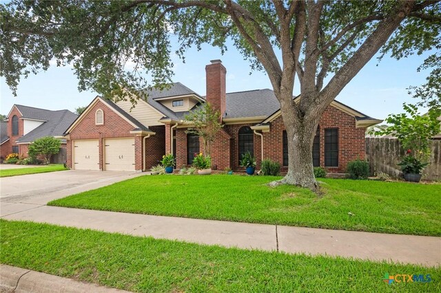 106 Westbrook Dr, Victoria, TX 77904 - view of front of home featuring brick siding, a garage, a chimney, and driveway