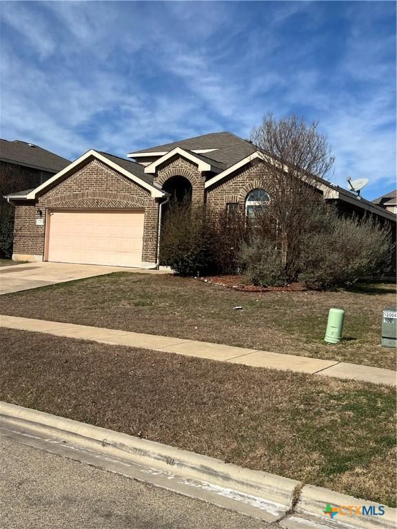 ranch-style house featuring a garage, concrete driveway, and brick siding