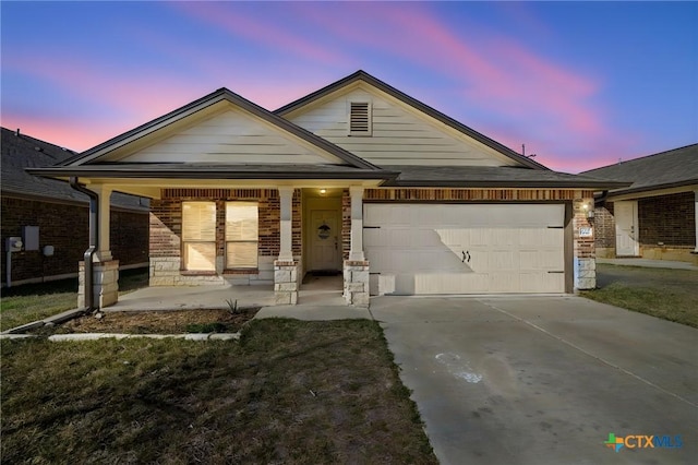 view of front facade featuring stone siding, covered porch, concrete driveway, an attached garage, and brick siding