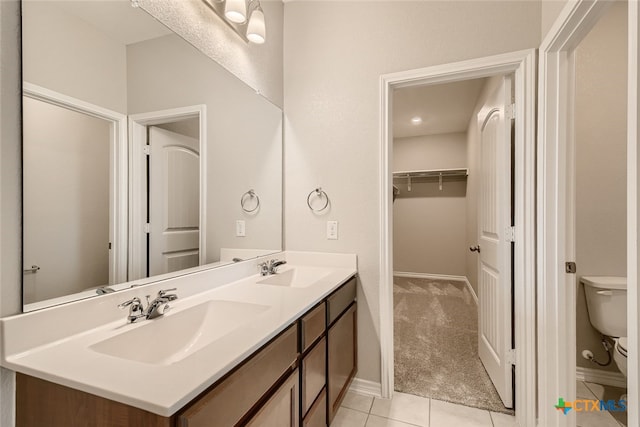 bathroom with toilet, vanity, and tile patterned floors